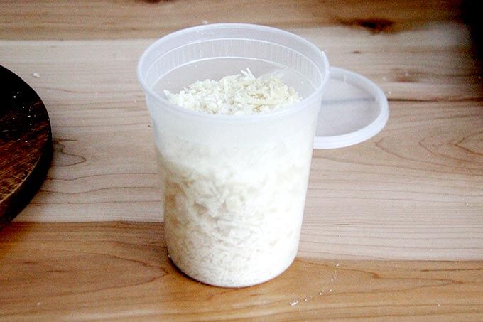 A quart container filled with grated parmesan.
