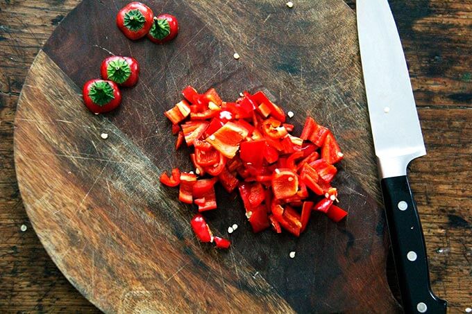 A cutting board with chopped hot chilies. 