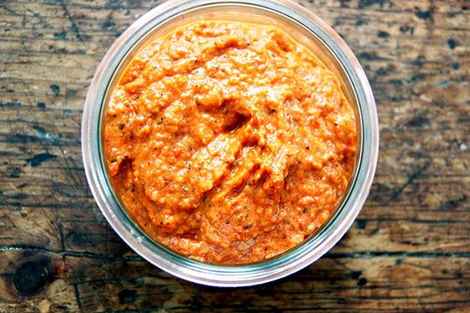 An overhead shot of a jar of homemade harissa paste. 