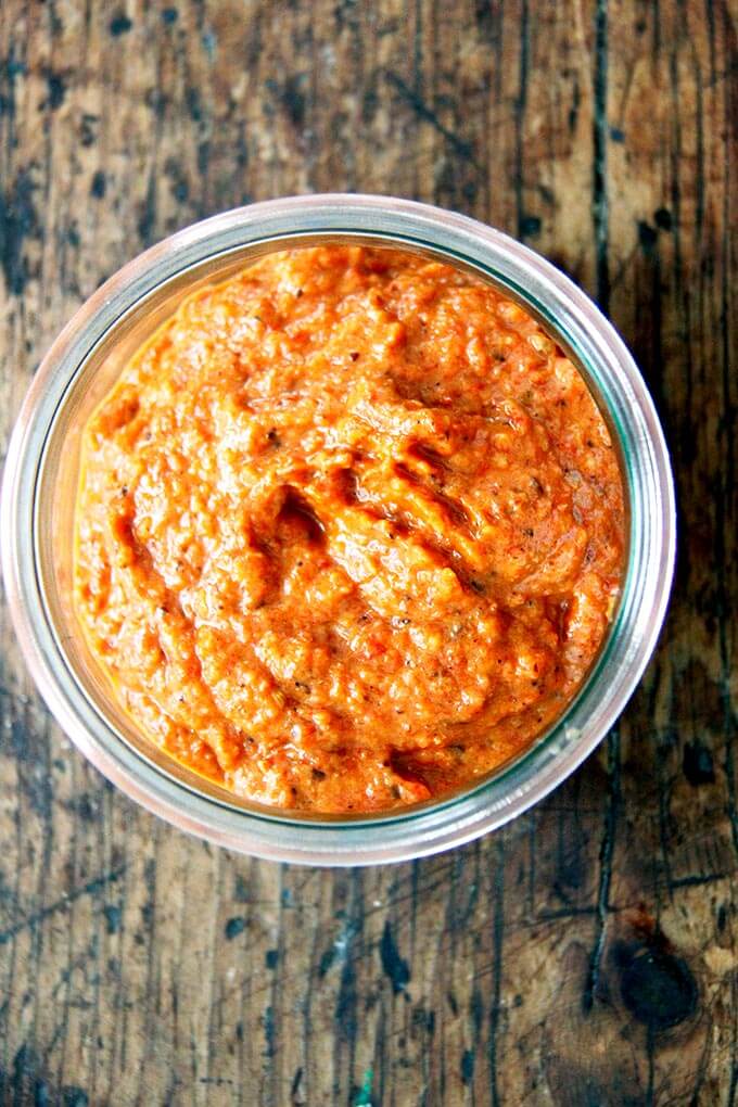 An overhead shot of a jar of homemade harissa paste. 