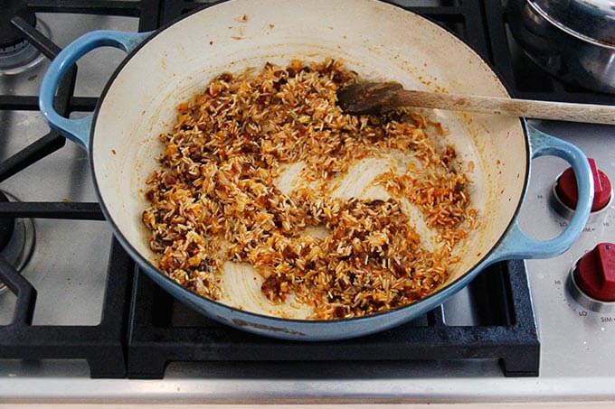 A skillet with Moroccan rice being cooked stovetop.