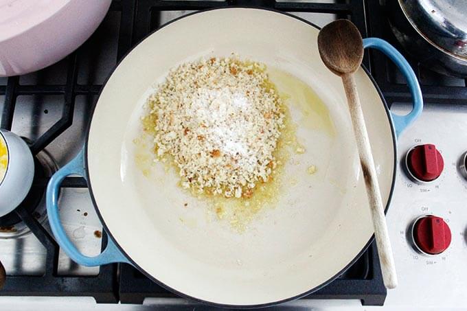 Olive oil in a skillet with bread crumbs.