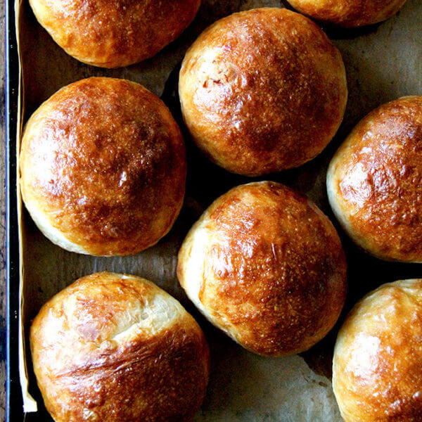 Brioche buns on a baking sheet.