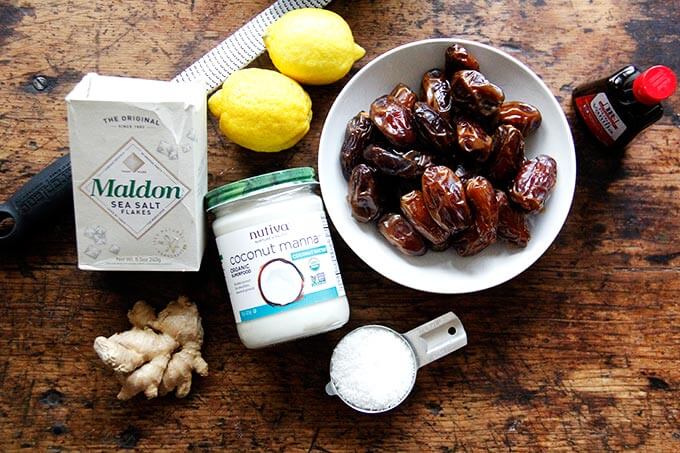 Ingredients to make lemon-coconut date balls on a board.