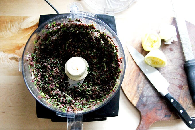 A food processor holding black olive tapenade.