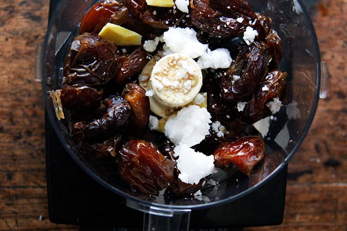 A food processor filled with the ingredients to make lemon coconut date balls.