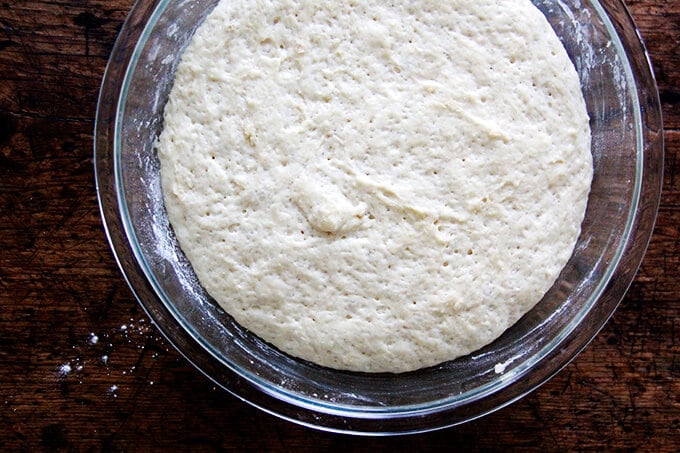 Brioche dough risen, filling up a large glass bowl. 