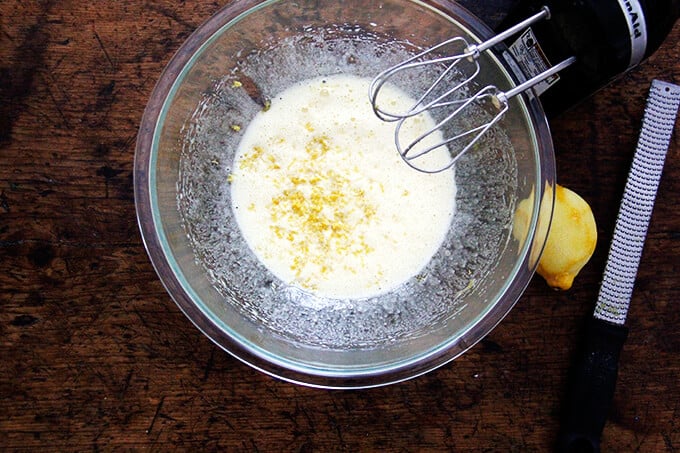 An overhead shot of eggs beaten with sugar and lemon zest.