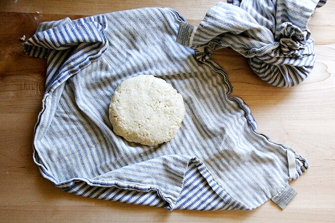 A tea towel with a round of food processor pastry dough. 