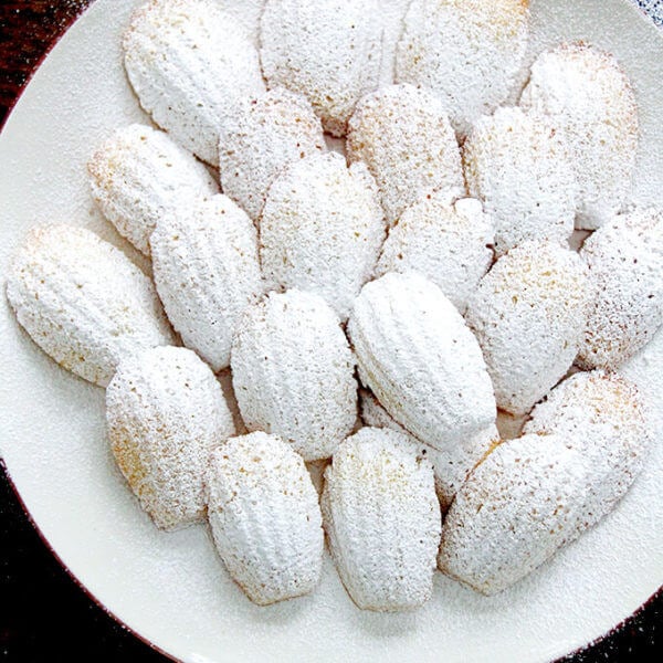 A plate of madeleines dusted with powdered sugar.