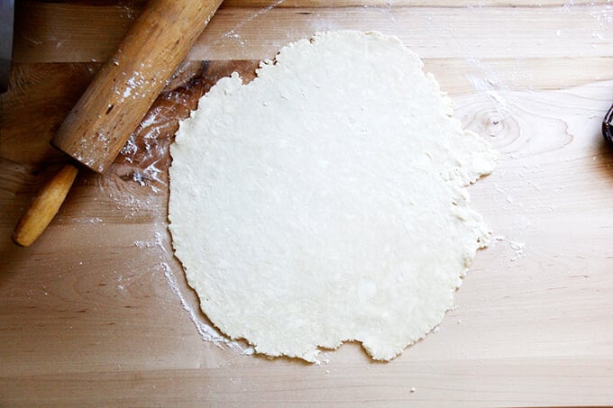 A floured board with a round of foolproof food processor pastry dough on it rolled into an 11-inch circle. 