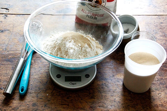 a scale with salt, flour, sugar, and yeast in it 