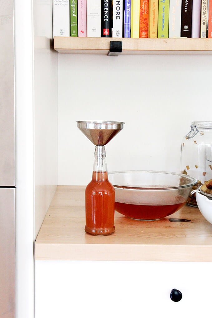 A jar of rhubarb schnapps with a funnel on top.