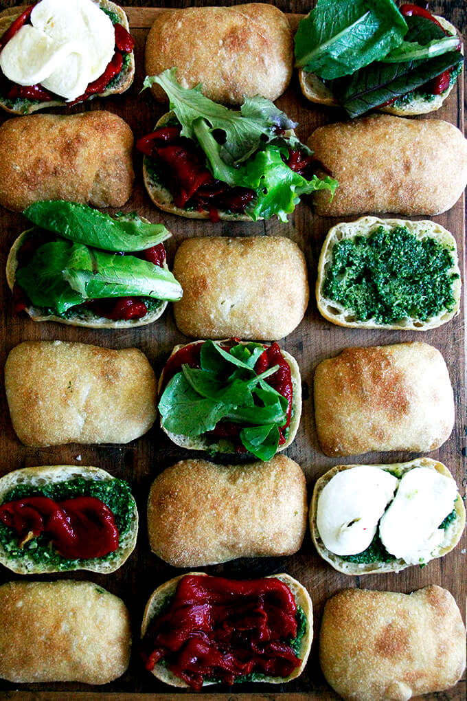 A board of roasted red pepper, mozzarella, and pesto sandwiches.