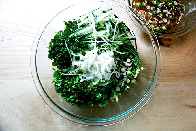 Cooked rice noodles with herbs, cucumbers, and scallions aside nuoc cham.