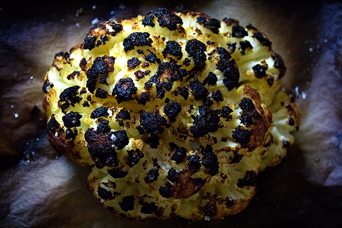 Up close shot of a head of whole roasted cauliflower.