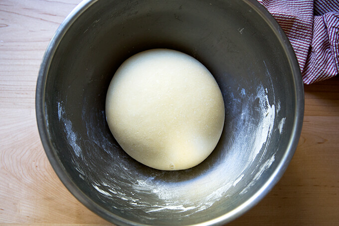 A bowl with a ball of risen dough.