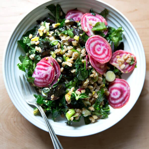 A white bowl filled with Charlie Bird farro salad and sliced beets.