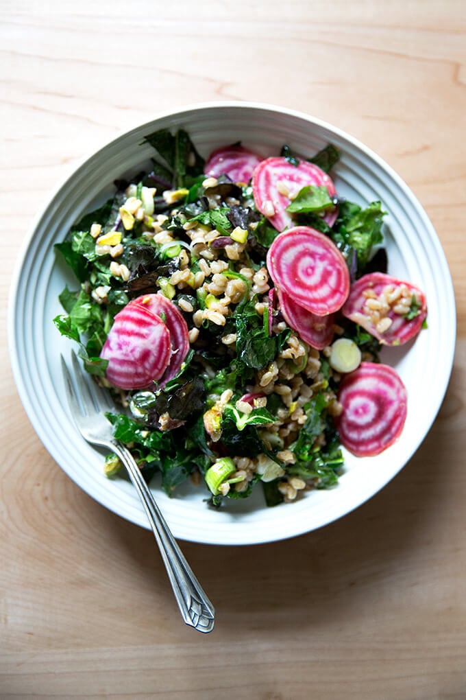 A white bowl filled with Charlie Bird farro salad and sliced beets.