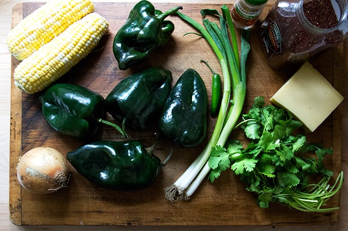 A board of ingredients: corn, poblanos, onion, scallions, cilantro, jalapeno, quinoa, and cheese.