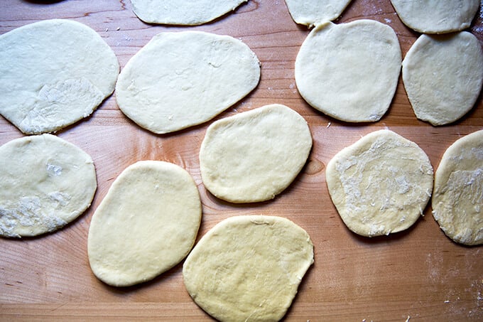 A work surface with 12 rounds of dough rolled out.
