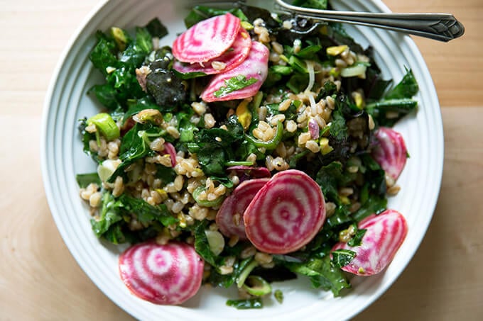 A white bowl filled with Charlie Bird farro salad and sliced beets.