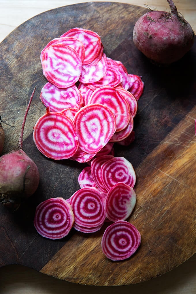 A board topped with thinly sliced candy striped beets.