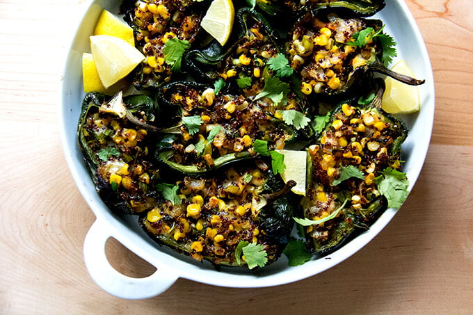 A pan of blistered poblano peppers stuffed with quinoa, corn, and Monterey Jack.