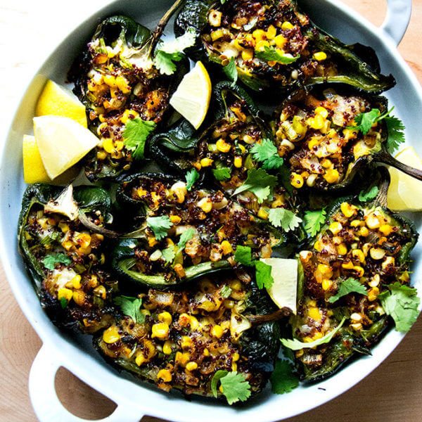 A pan of blistered poblano peppers stuffed with quinoa, corn, and Monterey Jack.