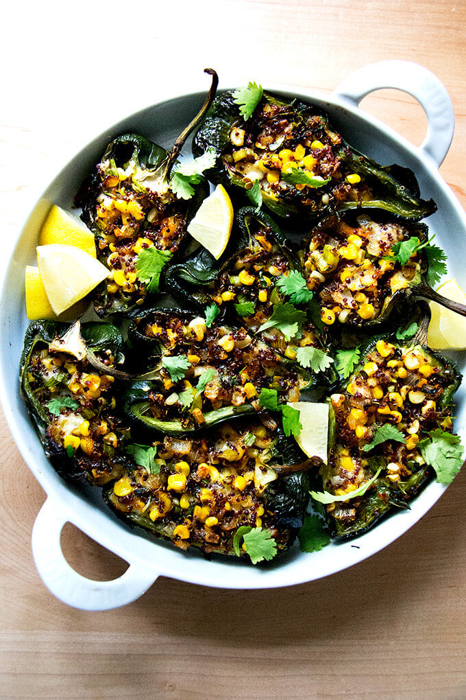 A pan of blistered poblano peppers stuffed with quinoa, corn, and Monterey Jack.