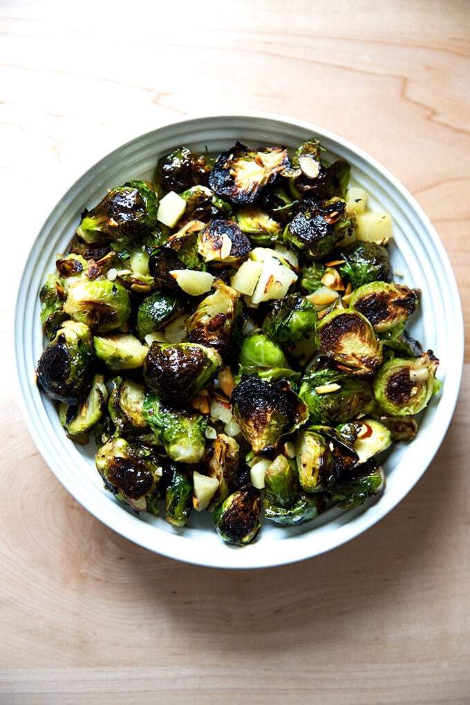 A bowl of roasted Brussels Sprouts with Almonds, Manchego, and balsamic.