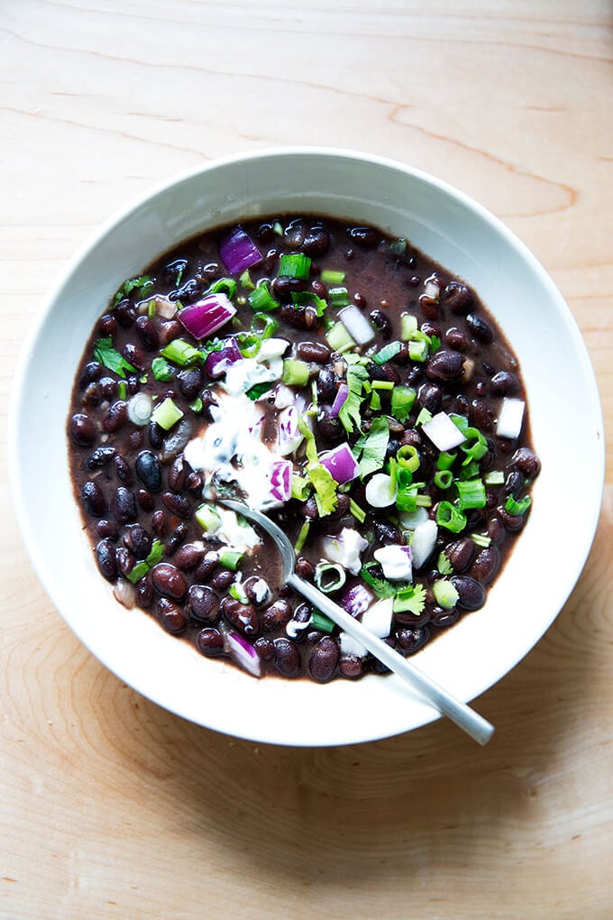 A bowl of black bean soup with all of the garnishes. 