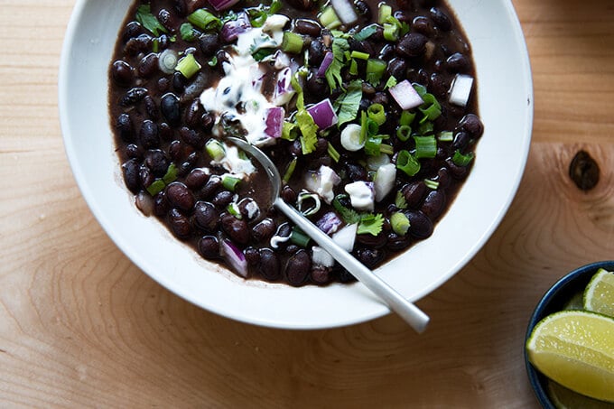 A bowl of black bean soup with all of the garnishes. 