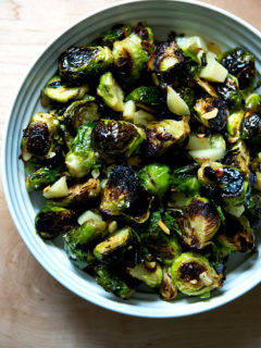 A bowl of roasted Brussels Sprouts with Almonds, Manchego, and balsamic.