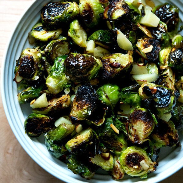 A bowl of roasted Brussels Sprouts with Almonds, Manchego, and balsamic.