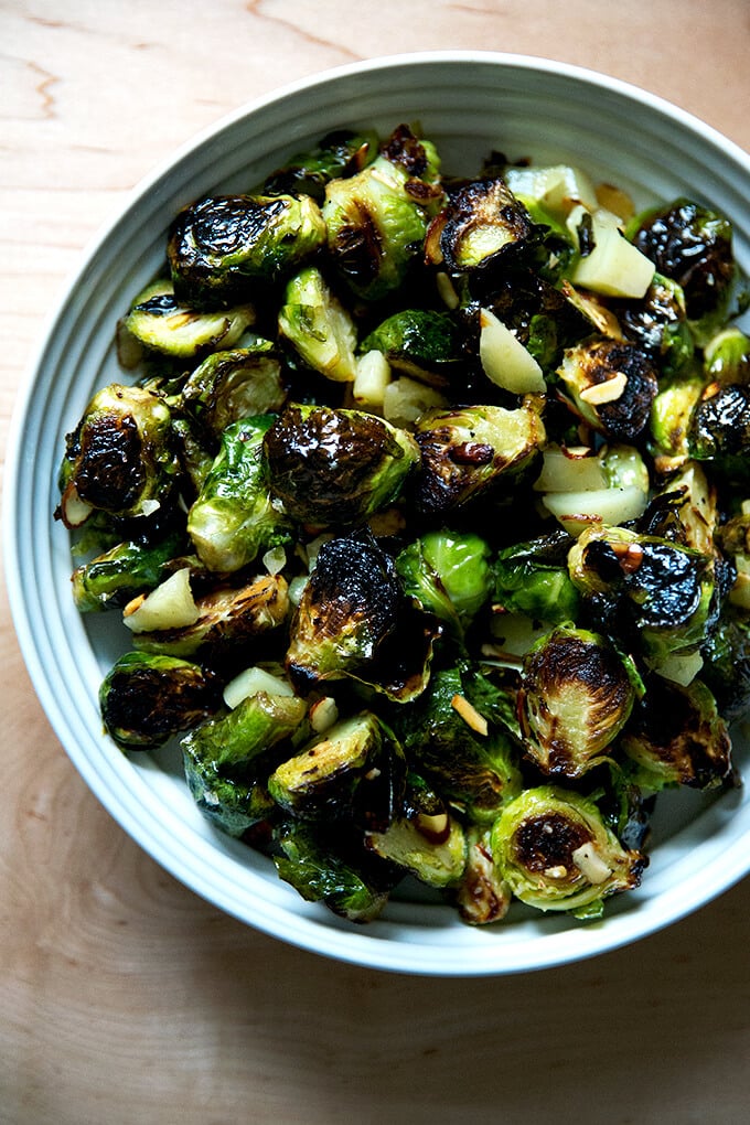 A bowl of roasted Brussels Sprouts with Almonds, Manchego, and balsamic.