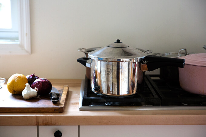 A stovetop pressure cooker on the stovetop cooking beans. 