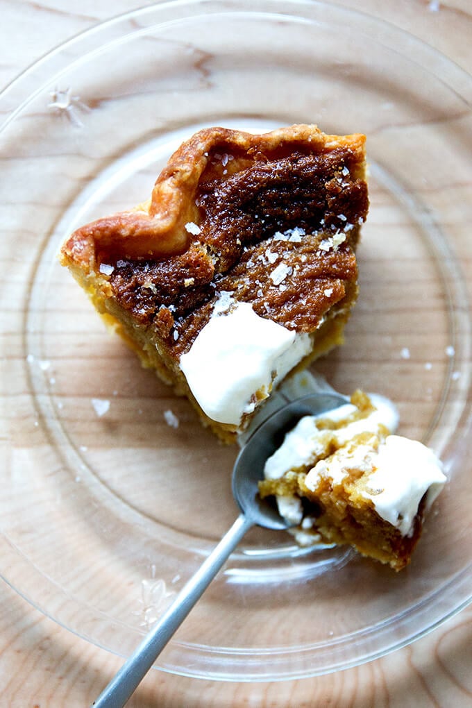 Sister Pie's Salted Maple Pie on a plate with whipped cream and a spoon.