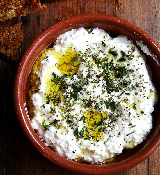 Homemade ricotta with herbs, olive oil, and grilled bread