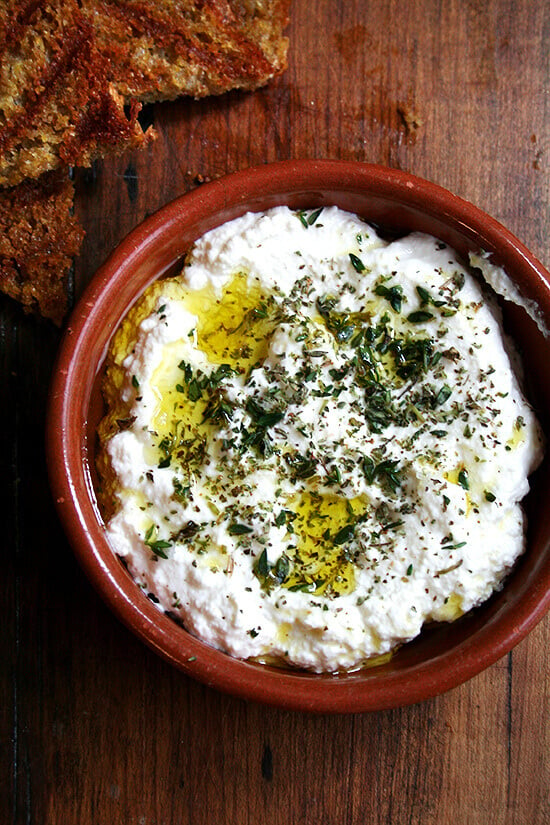 Homemade ricotta with herbs, olive oil, and grilled bread