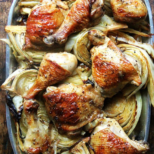 A platter of sheet pan chicken and cabbage.