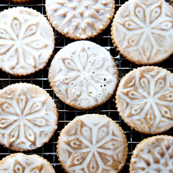 Stamped spiced brown butter muscovado cookies with maple glaze on a cooling rack.