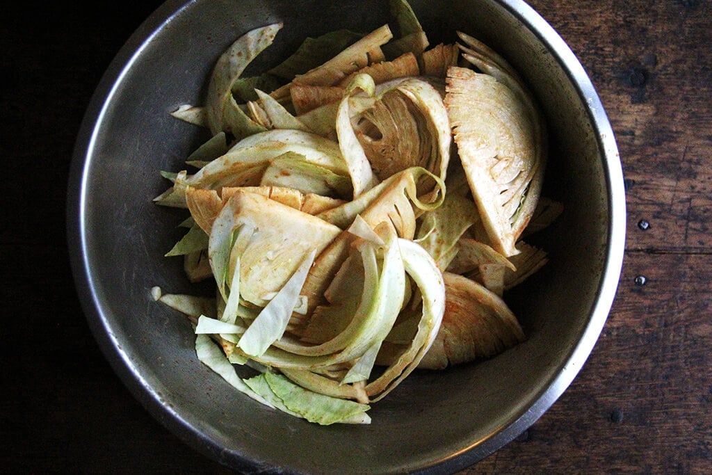 A bowl of cabbage wedges tossed in dressing.