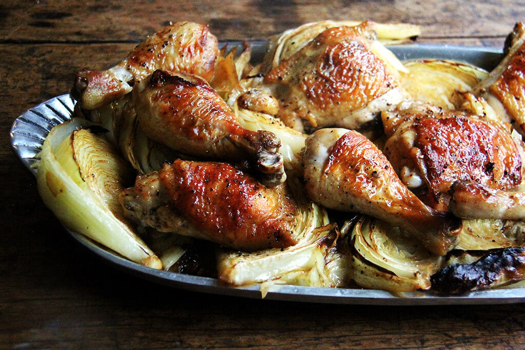 Sideview of a platter of sheet pan roast chicken and cabbage. 