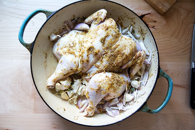 A braiser with a spatchcocked chicken rubbed with spices. 