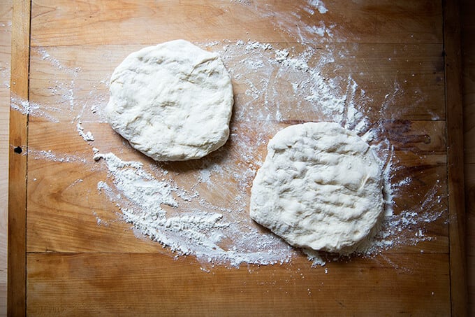 Cold, refrigerated homemade pizza dough on a floured work surface. 