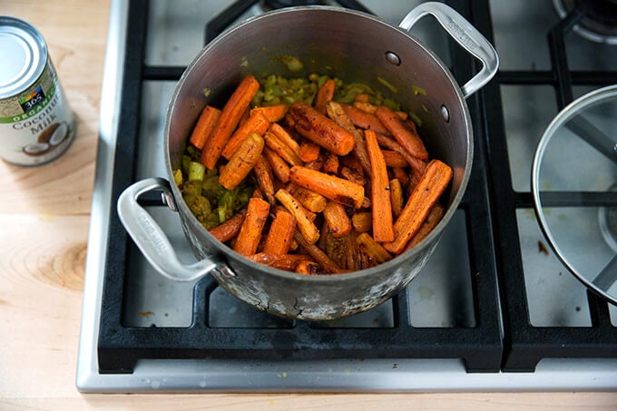 adding the roasted carrots to the vegan carrot-ginger soup with curry and coconut milk
