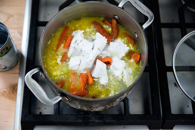 adding the coconut milk for the vegan carrot-ginger soup with curry and coconut milk