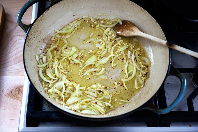 adding the garlic and pepper flakes to the sautéed onions