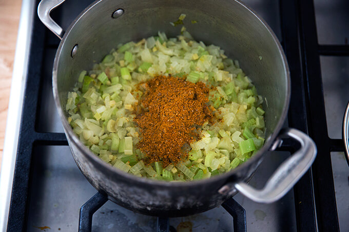 adding spices for the vegan carrot-ginger soup with curry and coconut milk